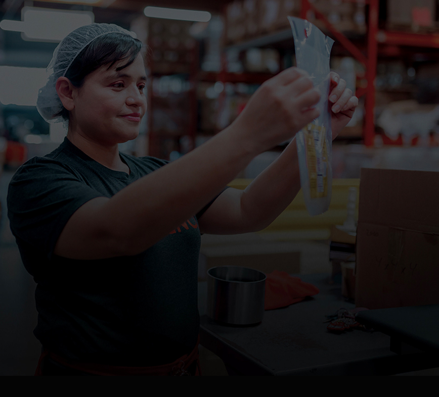 Great American Packaging worker holding a bag in the warehouse