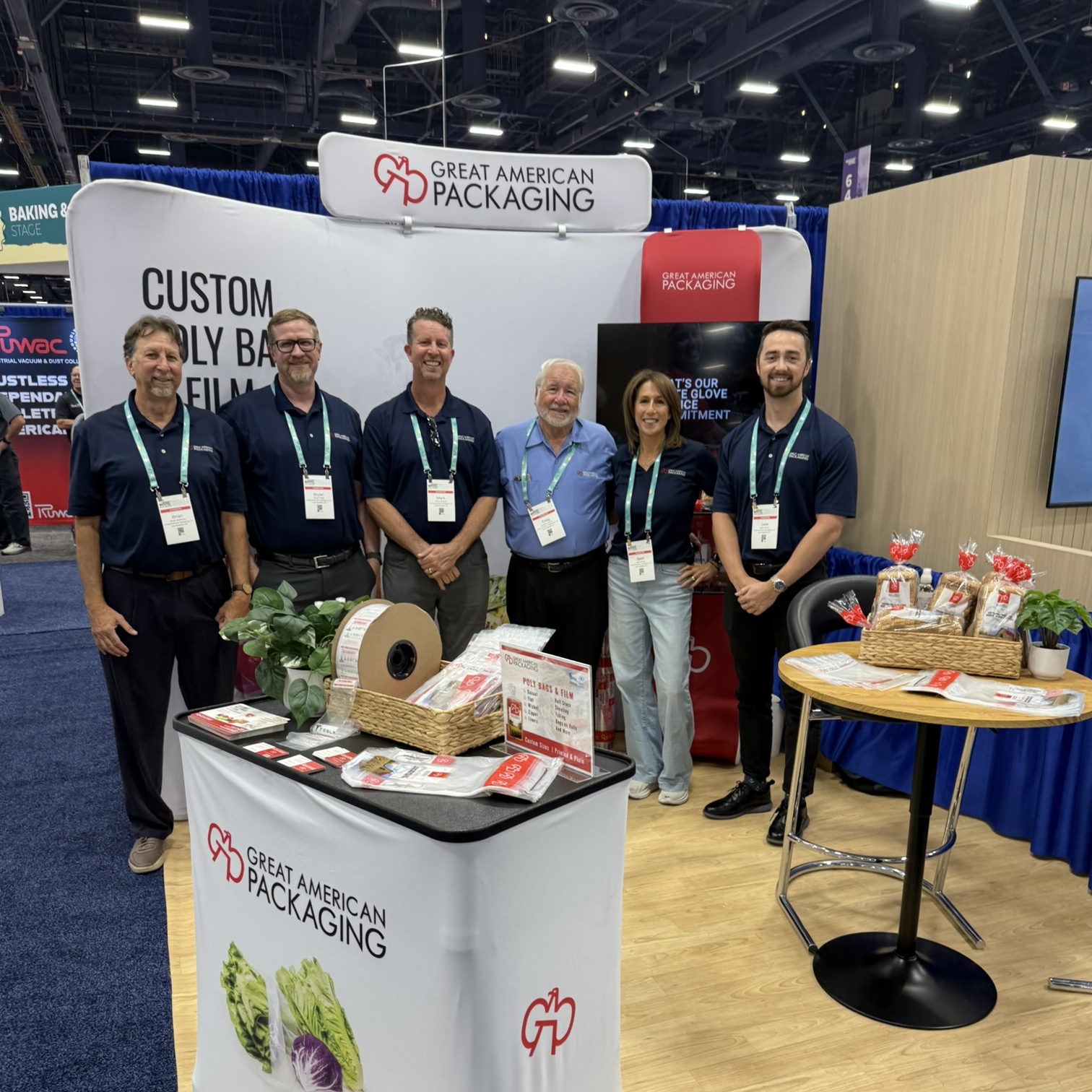 Great American Packaging team standing and smiling at IBIE 2025 booth