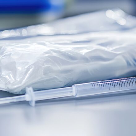 A close-up shot of a sterile syringe next to its packaging
